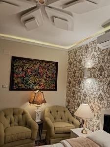 a bedroom with two chairs and a painting on the wall at 15 Bustan Down town in Cairo