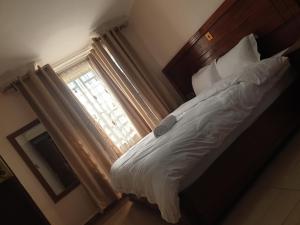 a bedroom with a bed and a window at The Golden Enclave Nakuru Fully Furnished Apartments in Nakuru