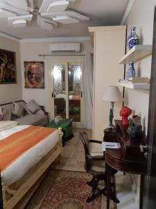 a bedroom with a bed and a desk and a table at 15 Bustan Down town in Cairo