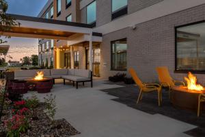 a patio with a couch and chairs and fire pits at Home2 Suites By Hilton Sheboygan in Sheboygan