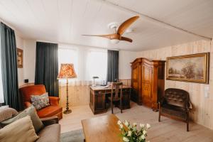 a living room with a ceiling fan and a desk at Altes Häusle am Waschbach-Weinberg in Edenkoben