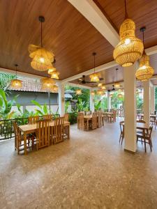 ein Restaurant mit Holzdecken und Holztischen und -stühlen in der Unterkunft Green Coco House in Amed