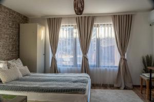 a bedroom with a bed and a large window at Guest House Malusha in Gabrovo