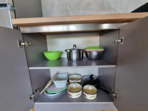 a kitchen cabinet with some pots and pans in it at Guest house in Dilijan , whole apartment with 2 bedrooms in Dilijan +7 photos