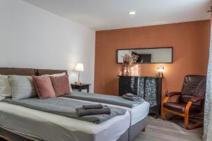 a bedroom with a large bed and a chair at Guest House Malusha in Gabrovo