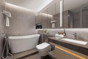 a bathroom with a tub and a toilet and a sink at Somerset Wanxia Shenzhen in Shenzhen