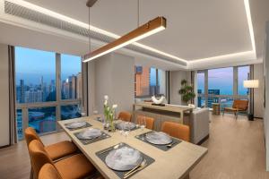 a dining room with a table and chairs with a view at Somerset Wanxia Shenzhen in Shenzhen