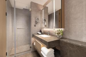 a bathroom with a sink and a shower at Somerset Wanxia Shenzhen in Shenzhen