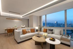 a living room with a couch and a table at Somerset Wanxia Shenzhen in Shenzhen