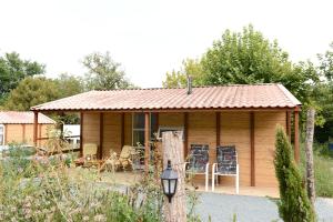 une cabane en rondins avec une table et des chaises dans une cour dans l'établissement BUNGALOW, à Saint-André-dʼAllas