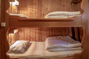 2 Etagenbetten in einem Zimmer mit Holzwänden in der Unterkunft Trysilfjellet Nord 1017 in Trysil