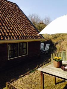 a table in front of a house with an umbrella at Dune Bep in Schiermonnikoog