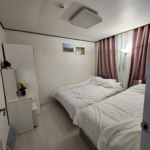 a small bedroom with two beds and a window at Sillim's Rest Area in Seoul