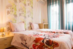 a bedroom with a bed with a flower patterned wall at Vitosha Downtown Apartments in Sofia