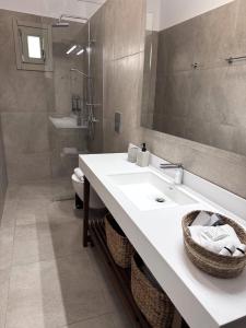 een badkamer met een wastafel, een toilet en een spiegel bij Urban Nest Kalymnos in Kalymnos +39 foto's