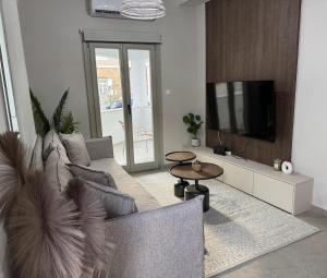 a living room with a couch and a tv at Urban Nest Kalymnos in Kalymnos