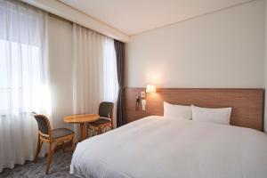 a hotel room with a bed and a table at Mito Sannomaru Hotel in Mito