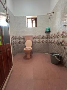baño con aseo y flores en la pared en Ozzys Salt and Surf Haven, en Varkala 6 fotos más