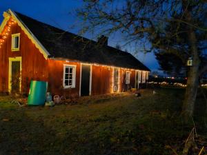 an old barn with lights on it at night at Happy Farm Storstuga in Källby +7 photos