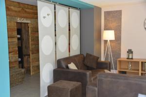 a living room with a couch and a chair at Couleur Nature, gîte de charme en Ardenne in Stoumont