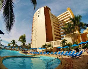 a large swimming pool with a large blue chair in front of it at Las Flores Beach Resort in Mazatlán