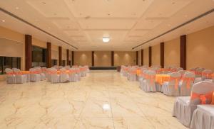 兰纳加Vanashraya Corbett Resort的大房间设有白色和橙色的桌子和椅子 更多91张照片