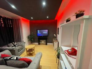 Una sala de estar con un sofá y un televisor. en Stylish 1 bedroom Flat Brixton, en Londres 5 fotos más