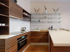 eine Küche mit Holzschränken und einer weißen Arbeitsplatte in der Unterkunft Magnificent two bedroom apartment in a luxury building in Genf