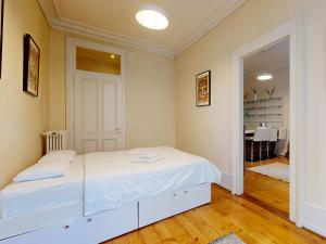 ein weißes Schlafzimmer mit einem weißen Bett in einem Zimmer in der Unterkunft Magnificent two bedroom apartment in a luxury building in Genf