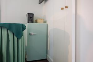an old blue refrigerator in a corner of a room at La Torretta in Tuscania
