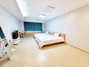 a hospital room with two beds and a television at Incheon Airport Line Guesthouse in Incheon