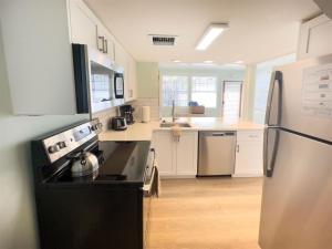 een keuken met een fornuis en een koelkast bij Orange Blossom Suite Conch Republic Cottage in Key West