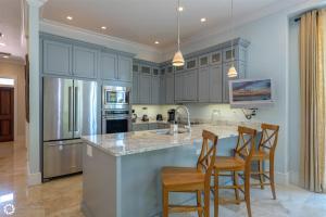 una cocina con armarios grises y una isla con taburetes. en Windsor Townhomes 6, en Key West