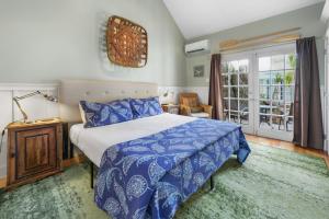 a bedroom with a bed with a blue comforter at Colony Poolside in Key West +9 photos