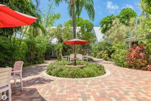 a patio with a table and a red umbrella at Bonaire Suite in Key West