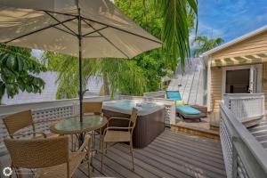 a patio with an umbrella and a table and chairs at Treetop Oasis Eyebrow House in Key West +3 photos