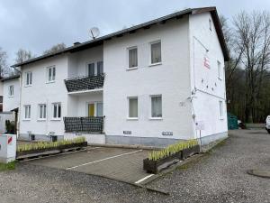 a white building with a parking lot in front of it at ZV-Scholtz Gästehaus Eisenfelden in Winhöring