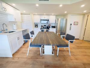 a large kitchen with a wooden table and chairs at Rum Cay Sunrise Suites in Key West