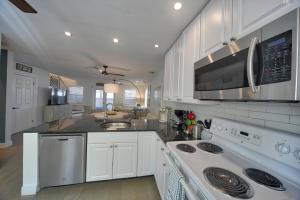 a kitchen with white cabinets and a stove top oven at Villa Serena Duval Square in Key West