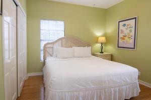 a bedroom with a white bed and a window at The Southern Cross Tropical Village in Key West