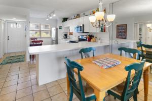 Una cocina y un comedor con mesa y sillas de madera. en La Brisa 303W, en Key West