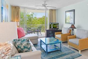 a living room with a couch and chairs and a table at Sunrise Suite 203 in Key West