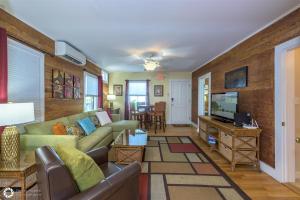 a living room with a couch and a tv at Eyebrow Suite Eyebrow House in Key West