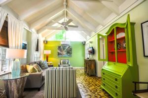 een woonkamer met groene muren en een plafond bij Ann Street Cottage in Key West