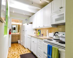 een keuken met witte kasten en een witte koelkast bij Ann Street Cottage in Key West +12 foto's