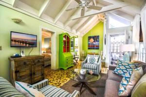 een woonkamer met een bank en een tv bij Ann Street Cottage in Key West