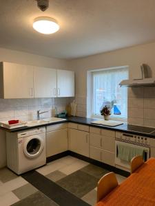 a kitchen with a sink and a washing machine at ZV-Scholtz Gästehaus Eisenfelden in Winhöring