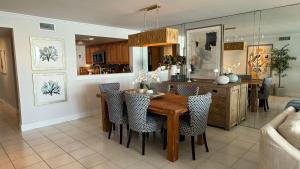 a kitchen and dining room with a wooden table and chairs at Glimmer Glass Kw Beach Club in Key West
