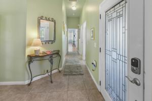 a hallway with a table and a mirror and a door at Duval Square Courtyard Condo 31 in Key West
