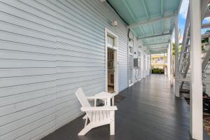 a white chair sitting on the porch of a house at La Casa De Luces in Key West